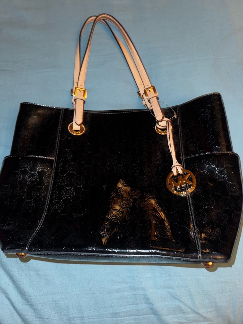 Michael Kors Jet Set patent leather tote with a signature embossed logo pattern